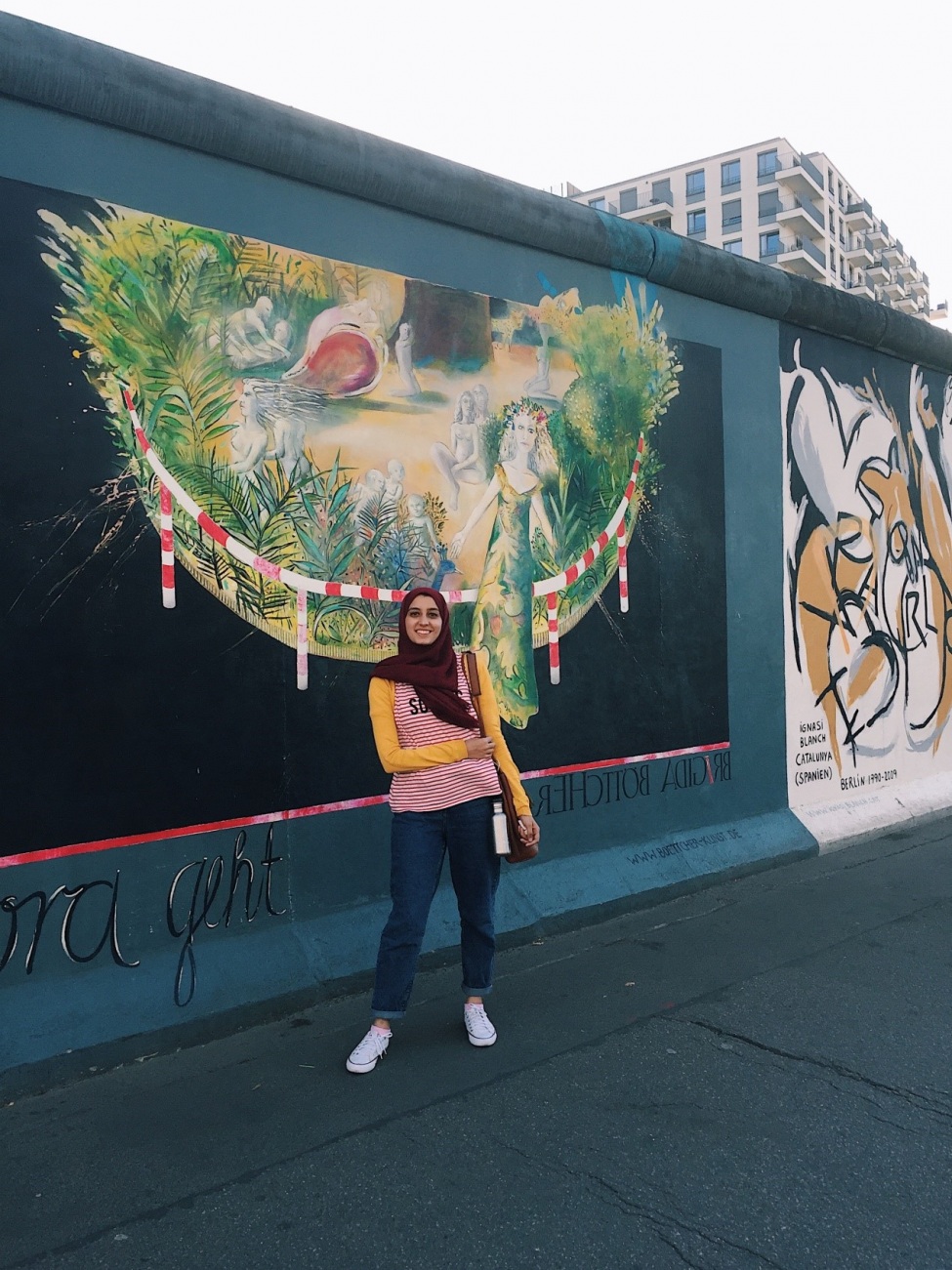 Salma vor einem Stück der alten Berliner Mauer