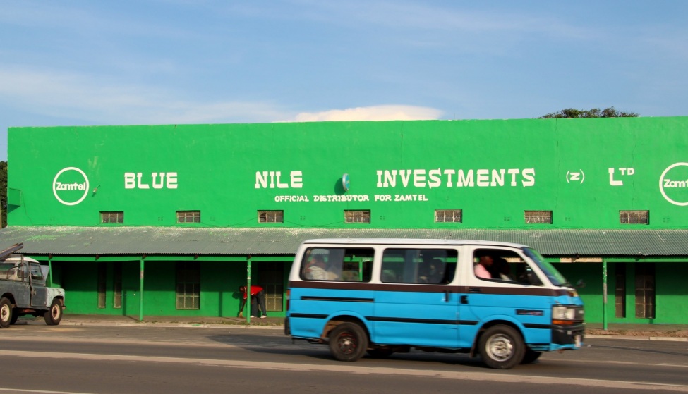 Straßenszene in Lusaka, ein Bus fährt durchs Bild