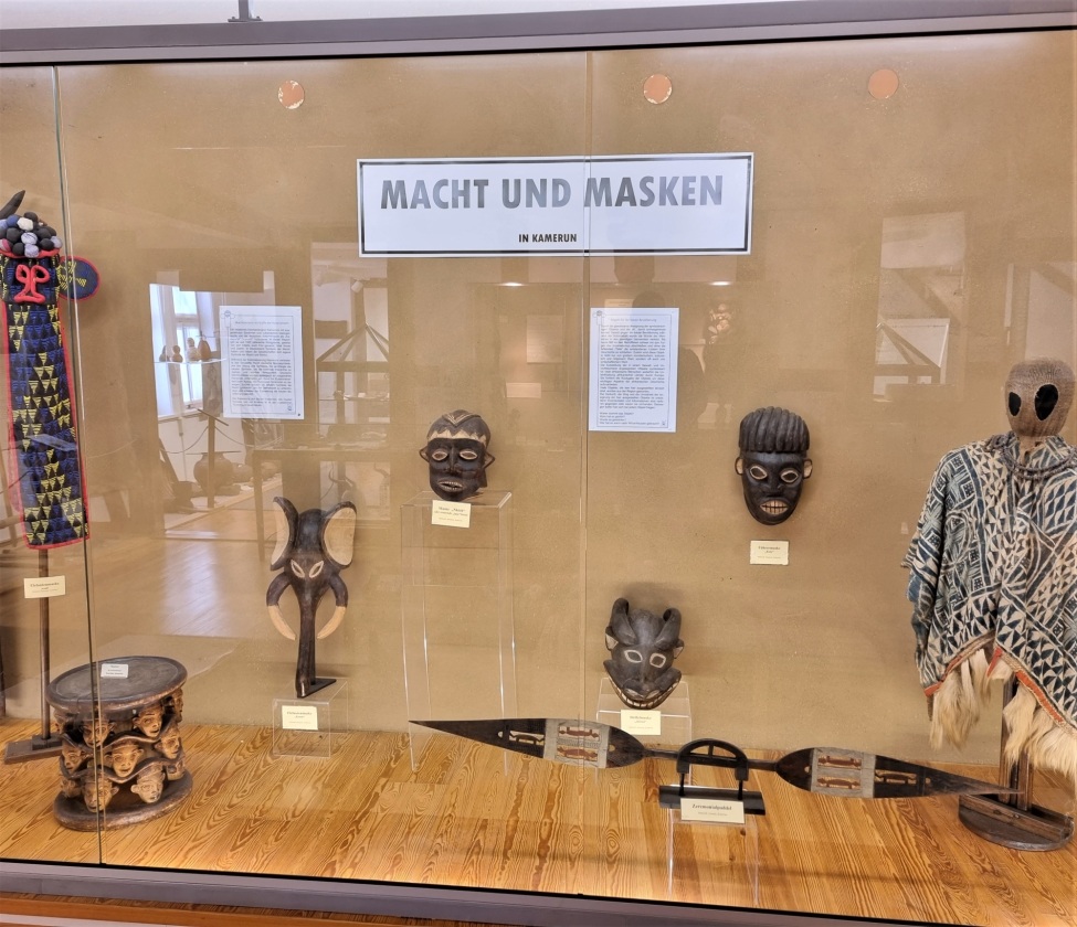 Ausstellungsvitrine mit afrikanischen Masken und dem Titel "Macht und Masken", Foto: DITSL