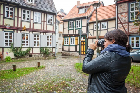 Junge Frau fotografiert ein Haus in einer Welterbestätte.