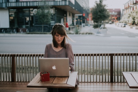 Junge Frau in einem Café am PC sitzend