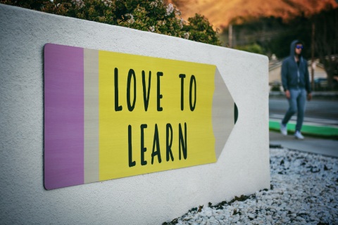 Schild an einer Wand mit Aufschrift "Love to Learn"